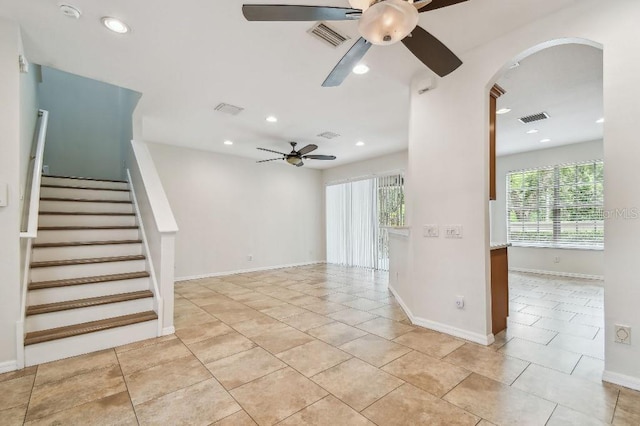 interior space with a ceiling fan, arched walkways, visible vents, and a healthy amount of sunlight