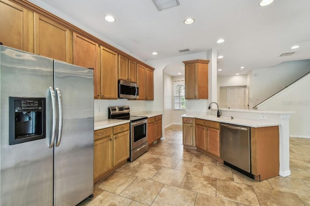 kitchen with stainless steel appliances, baseboards, visible vents, and brown cabinetry