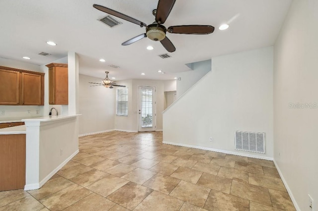 unfurnished living room with baseboards, a ceiling fan, and visible vents