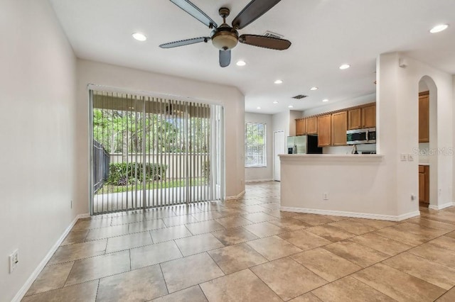 unfurnished living room featuring recessed lighting, ceiling fan, and arched walkways