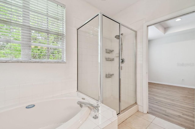 full bath with tile patterned floors, a bath, and a shower stall