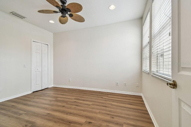 unfurnished room with a ceiling fan, baseboards, recessed lighting, wood finished floors, and visible vents