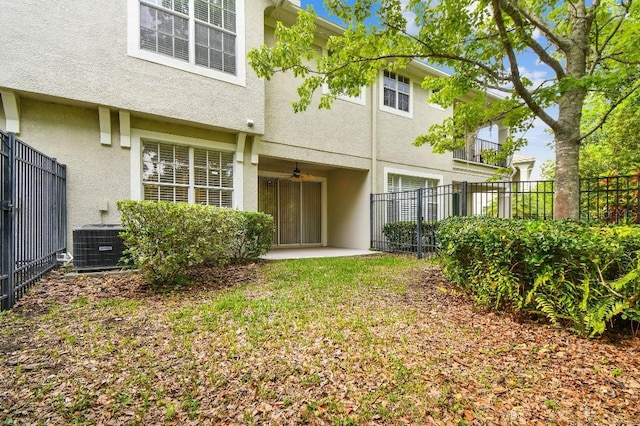 rear view of property with fence, a ceiling fan, and stucco siding