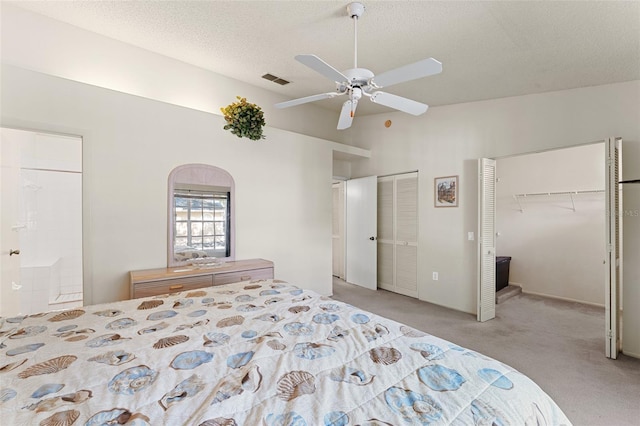 2373 Hounds Trl, Palm Harbor, FL 34683 - bedroom with a textured ceiling, visible vents, light colored carpet, multiple closets, and ensuite bath