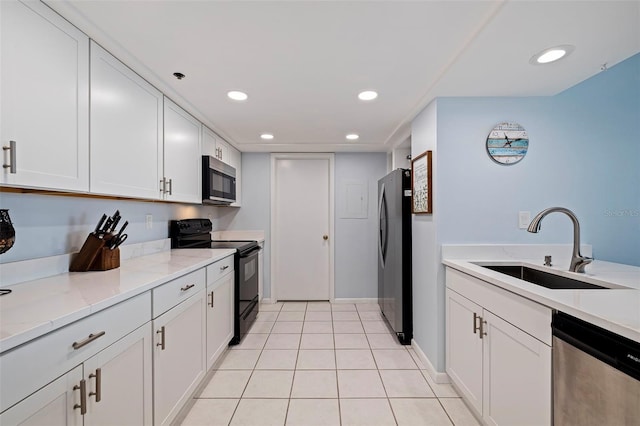 kitchen featuring recessed lighting, white cabinetry, light stone counters, a sink, and stainless steel appliances