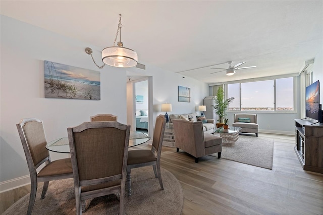 dining area featuring baseboards, a ceiling fan, light wood-style flooring, and visible vents