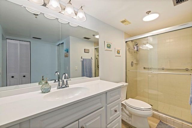 bathroom featuring visible vents, toilet, and a shower stall