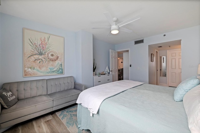 bedroom with a ceiling fan, wood finished floors, and visible vents