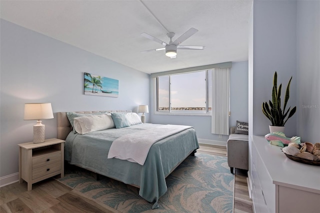 bedroom featuring baseboards, a ceiling fan, and wood finished floors
