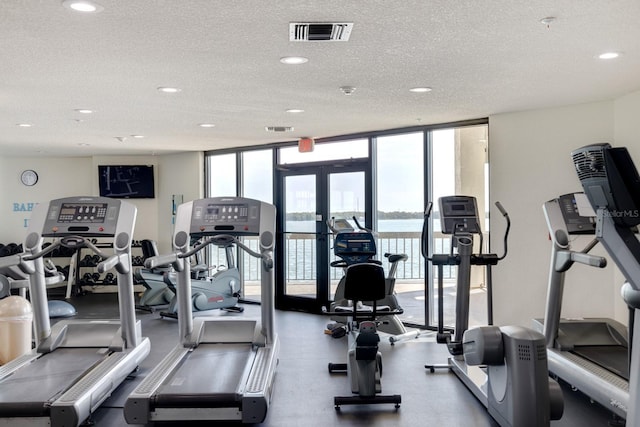 workout area with recessed lighting, a textured ceiling, a wall of windows, and visible vents