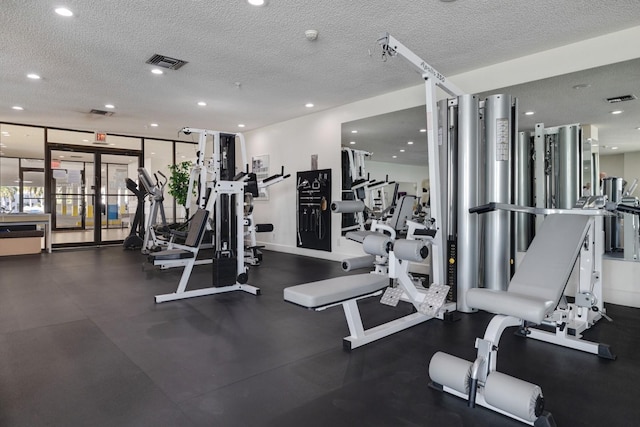 exercise room with recessed lighting, a textured ceiling, and visible vents