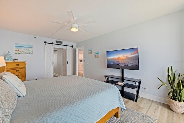 6287 Bahia Del Mar Cir Unit 801, Saint Petersburg, FL 33715 - bedroom with a barn door, light wood-style flooring, a ceiling fan, and baseboards