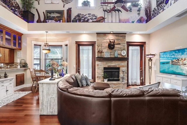18929 Crescent Rd, Odessa, FL 33556 - living area featuring a high ceiling, dark wood-style floors, a ceiling fan, and a stone fireplace