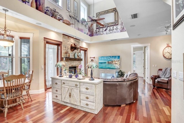 18929 Crescent Rd, Odessa, FL 33556 - living room with ceiling fan, light wood-style floors, a stone fireplace, a towering ceiling, and baseboards