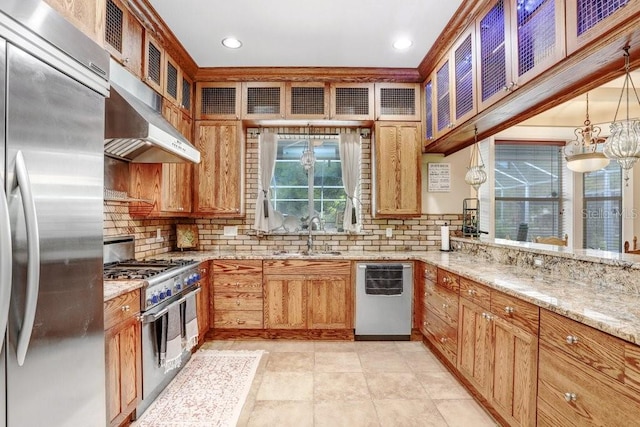 18929 Crescent Rd, Odessa, FL 33556 - kitchen with stainless steel appliances, a sink, tasteful backsplash, under cabinet range hood, and light stone countertops