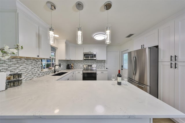 kitchen featuring appliances with stainless steel finishes, a sink, white cabinetry, tasteful backsplash, and visible vents