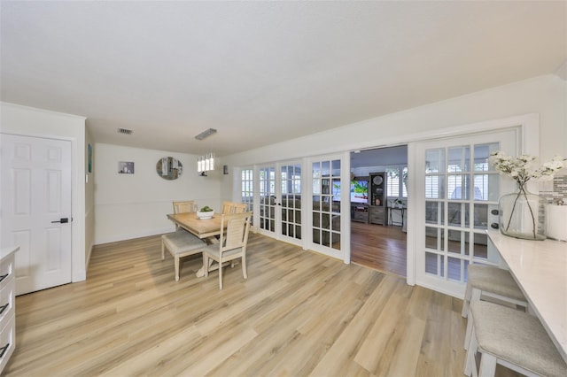 dining room with visible vents, french doors, and light wood-type flooring