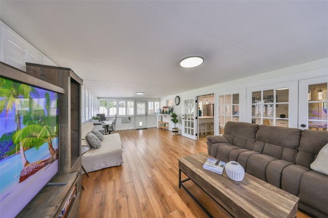 living room with french doors and light wood finished floors