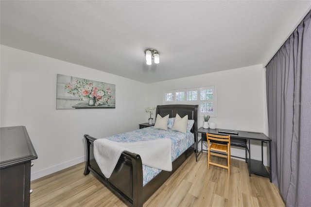 bedroom featuring baseboards and light wood-style flooring
