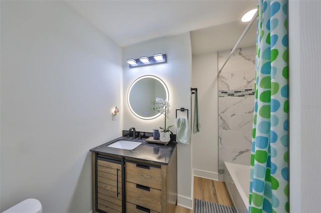 full bathroom with vanity, wood finished floors, shower / bath combination with curtain, toilet, and baseboards
