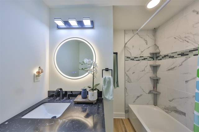 bathroom with wood finished floors, shower / bathing tub combination, and vanity