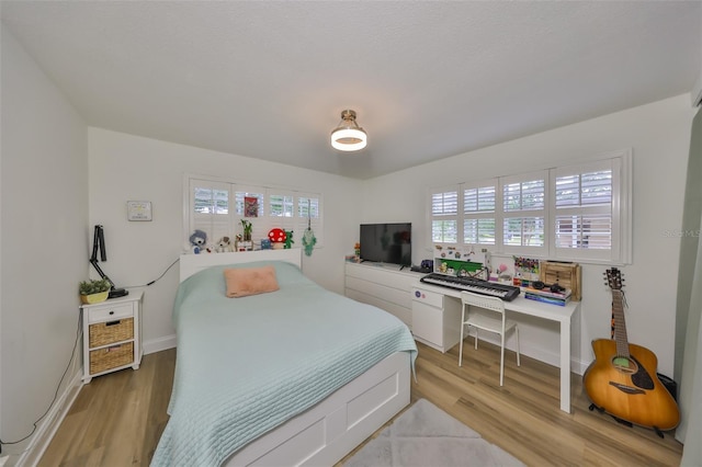 bedroom featuring baseboards and light wood finished floors
