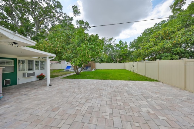 view of patio with a fenced backyard and a wall unit AC