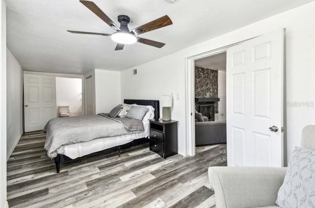 1247 21st St, Sarasota, FL 34234 - bedroom with wood finished floors, a ceiling fan, and a fireplace