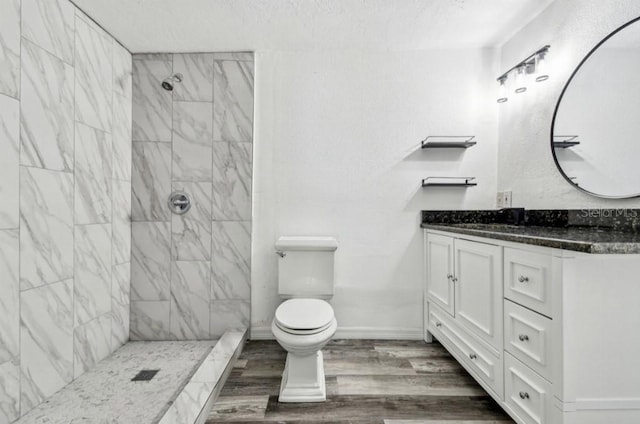1247 21st St, Sarasota, FL 34234 - bathroom with vanity, toilet, tiled shower, wood finished floors, and a textured ceiling
