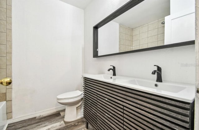 1247 21st St, Sarasota, FL 34234 - full bath featuring toilet, wood finished floors, double vanity, baseboards, and shower / bathtub combination