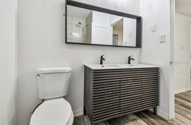 1247 21st St, Sarasota, FL 34234 - bathroom with wood finished floors, toilet, double vanity, and baseboards
