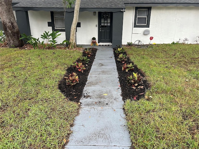 1247 21st St, Sarasota, FL 34234 - entrance to property featuring a shingled roof, stucco siding, and a yard