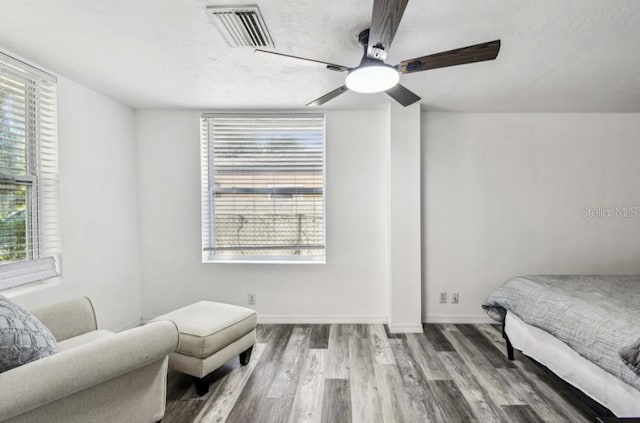 1247 21st St, Sarasota, FL 34234 - bedroom with wood finished floors, multiple windows, baseboards, and a ceiling fan