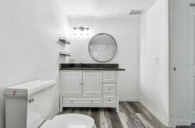 1247 21st St, Sarasota, FL 34234 - bathroom with toilet, wood finished floors, vanity, and baseboards