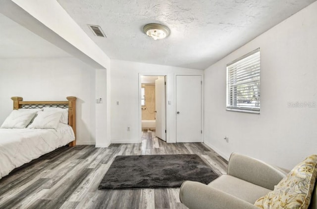 1247 21st St, Sarasota, FL 34234 - bedroom featuring wood finished floors, baseboards, ensuite bathroom, and vaulted ceiling