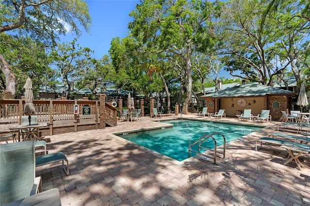 pool with a patio and fence