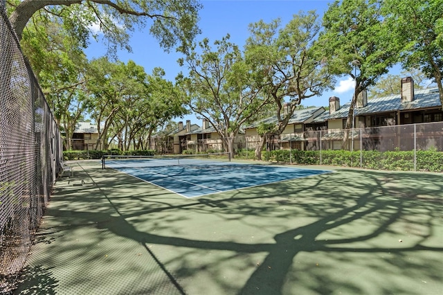 view of sport court featuring fence and a residential view