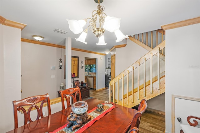 dining space with crown molding, a notable chandelier, wood finished floors, and stairway