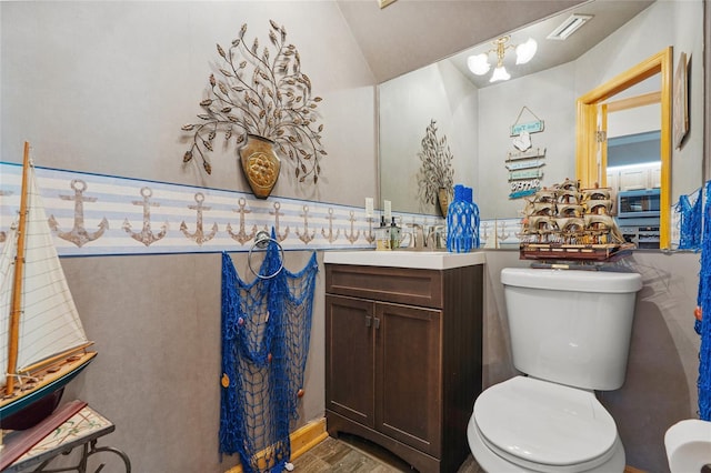 bathroom with visible vents, wood finished floors, vanity, toilet, and lofted ceiling