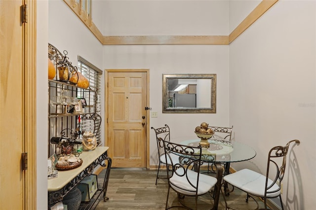 dining area with baseboards, a high ceiling, and wood finished floors