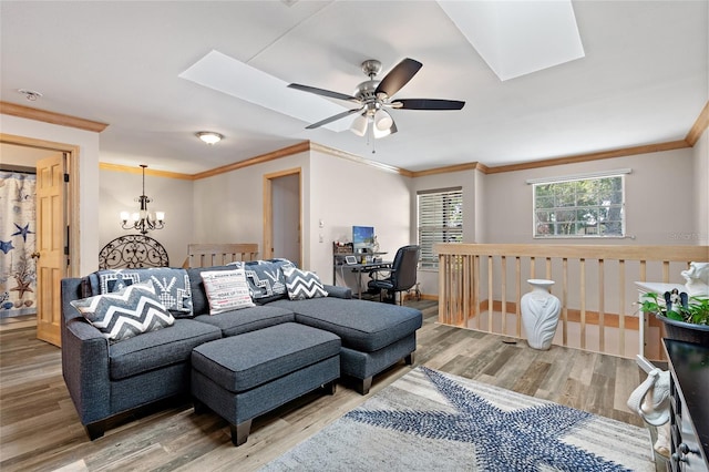 living area with ornamental molding, wood finished floors, and ceiling fan with notable chandelier