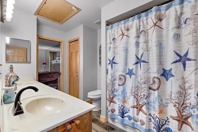 full bathroom with a sink, double vanity, toilet, wood finished floors, and visible vents