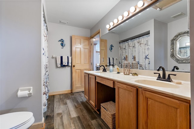 bathroom with a sink, wood finished floors, and visible vents