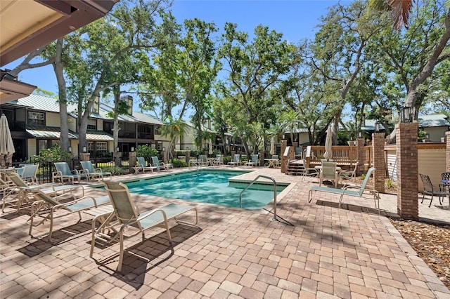 pool featuring fence and a patio area