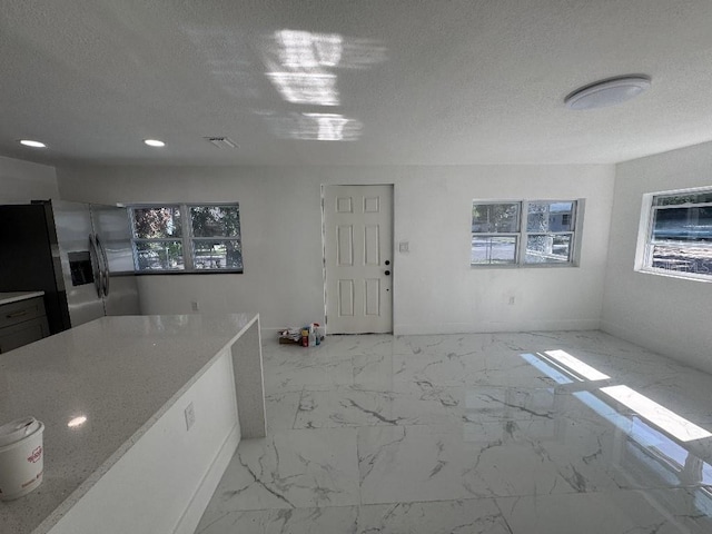 547 16th Ave S, Saint Petersburg, FL 33701 - kitchen with stainless steel fridge with ice dispenser, marble finish floors, a textured ceiling, recessed lighting, and baseboards