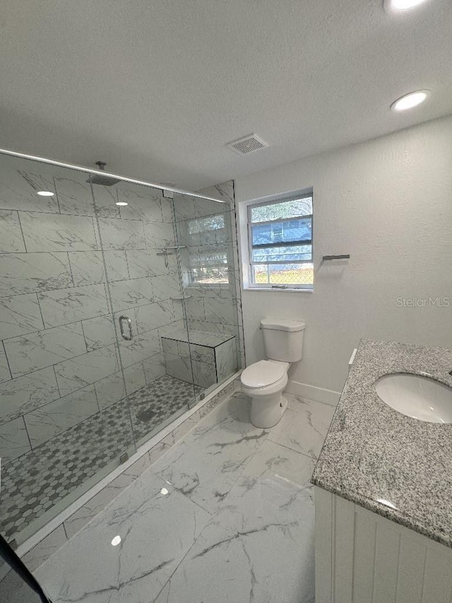 547 16th Ave S, Saint Petersburg, FL 33701 - bathroom with vanity, a shower stall, marble look tiles, a textured ceiling, and toilet