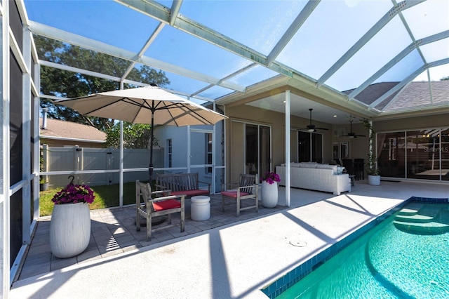view of pool with a fenced in pool, a ceiling fan, glass enclosure, and a patio area