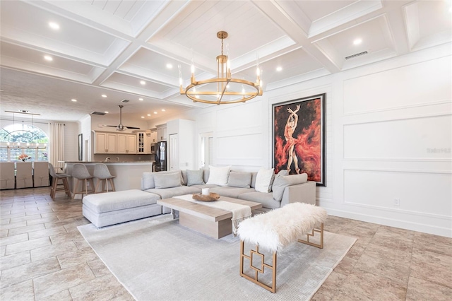 living area featuring coffered ceiling, a decorative wall, and a notable chandelier