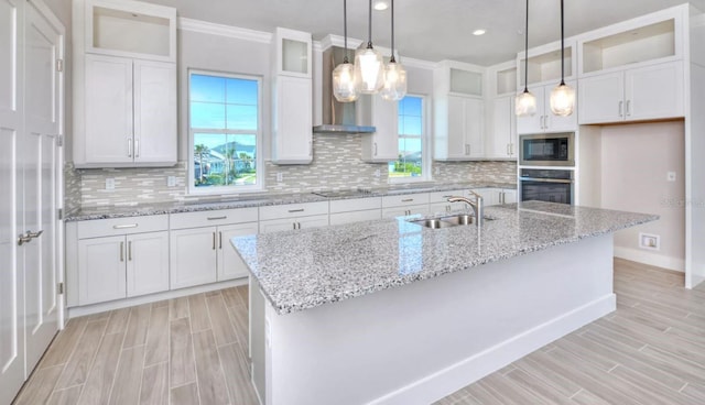 kitchen with oven, wood finish floors, built in microwave, white cabinets, and a sink