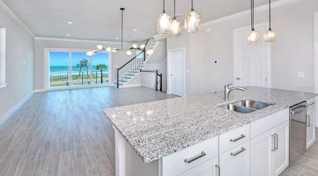 kitchen with stainless steel dishwasher, an inviting chandelier, a sink, and light wood finished floors
